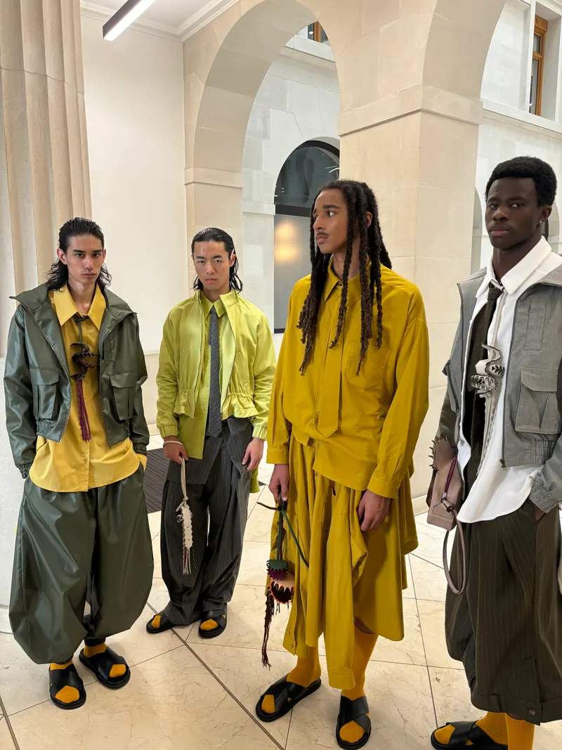 Four models in mustard, olive, lime and grey outfits, a second pose